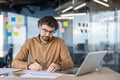 Focused businessman working with documents and laptop in office Royalty Free Stock Photo