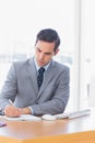 Focused businessman writing at his desk Royalty Free Stock Photo