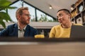 Focused businesspeople collaborating on new project two young entrepreneurs using laptop while working together in modern Royalty Free Stock Photo