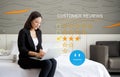 Focused businesswoman perusing through customer reviews on her laptop while sitting comfortably on a bed in a calm and serene Royalty Free Stock Photo