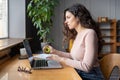 Focused businesswoman work on laptop hold expander in hand massaging muscles after computer overwork