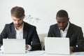 Focused busy diverse businessmen working on laptops sharing offi Royalty Free Stock Photo
