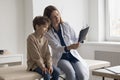 Focused family doctor woman and patient kid watching Xray scan