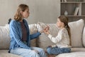 Focused caring young mother teaching little kid daughter pronouncing sounds.