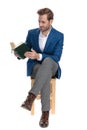 Focused casual guy reading a book while sitting