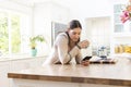 Focused caucasian woman holding mug and using smartphone in kitchen at home, copy space Royalty Free Stock Photo