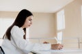 Woman sitting at desk, reading from laptop, writing notes at her notebook Royalty Free Stock Photo