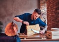 Focused chef cook cutting exclusive jerky meat on a table in kitchen with loft interior.