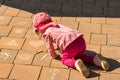 Focused child drawing on on stone tiles with chalk outdoors