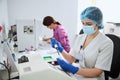 Young lab worker performing a biochemical analysis in latex gloves