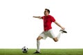 Focused and competitive young male soccer player in motion during football game on field, hitting ball isolated on white Royalty Free Stock Photo