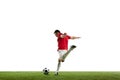 Focused and competitive young male soccer player in motion during football game on field, hitting ball isolated on white Royalty Free Stock Photo