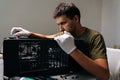 Focused computer technician in protective white gloves carefully installing internal hardware components inside open Royalty Free Stock Photo