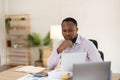 Focused concentrated young african businessman sit at desk look at laptop, serious afro american male professional Royalty Free Stock Photo