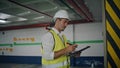 Focused contractor writing clipboard working at parking closeup. Man in helmet Royalty Free Stock Photo