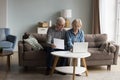 Focused couple of older senior pensioners checking domestic financial papers