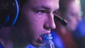 Focused cyber sportsman with bottle watching replay