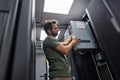 Data center technician installing server hardware and cabling in a server rack during maintenance work Royalty Free Stock Photo