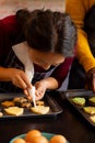 Focused diverse couple in aprons decorating christmas cookies in kitchen