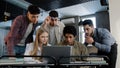 Focused diverse team corporate employees colleagues in office looking at laptop screen reading good news happy excited Royalty Free Stock Photo