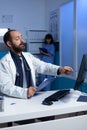 Focused doctor pointing at computer for analysis work at night