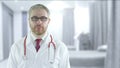 Focused doctor with red stethoscope in a modern hospital ward