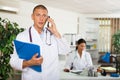 Focused doctor talking on phone in medical clinic office