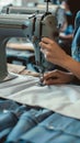 Focused dressmaker sews clothes meticulously on factory sewing machine