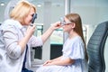 Focused eye doctor conducting dynamic retinoscopy on pediatric patient Royalty Free Stock Photo