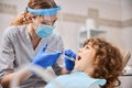 Professional dentist is giving anesthesia to a child
