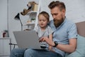 focused father and son using laptop together Royalty Free Stock Photo