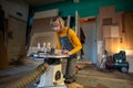 Pedant woman joiner works in joinery workshop, sanding, turning wooden knife blanks on lathe Royalty Free Stock Photo