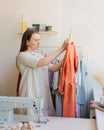 Focused female owner of local clothing business with newly sewn dress Royalty Free Stock Photo