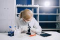 focused female science student looking in a microscope in a laboratory Royalty Free Stock Photo