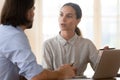 Focused female trainee asking for advice from team leader. Royalty Free Stock Photo