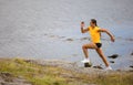 Focused fitness woman doing high-intensity running on mountainside by the sea Royalty Free Stock Photo