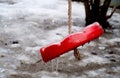 Focused frozen simple red swing for children in the winter Royalty Free Stock Photo