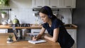 Focused gen Z university student girl in headphones using laptop Royalty Free Stock Photo