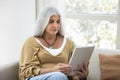 Focused grey haired senior lady using tablet at home Royalty Free Stock Photo