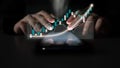 Hands manipulating data analytics on a smartphone with glowing graphs representing financial trends and stock market Royalty Free Stock Photo