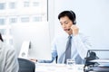 Handsome Asian man working in call center office as a telemarketing operator Royalty Free Stock Photo