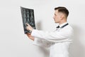 Focused handsome young doctor man holds x-ray radiographic image ct scan mri isolated on white background. Male doctor Royalty Free Stock Photo