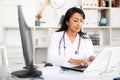 Focused female doctor working with laptop in clinic office Royalty Free Stock Photo