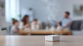Focused image of a compact sensor unit on a table detecting fine particulates with a blurred family space in the Royalty Free Stock Photo