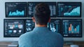 Focused individual analyzing data trends on multiple monitors in a modern workspace