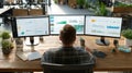 Person Working at Desk with Multiple Monitors and Analytics Charts Royalty Free Stock Photo