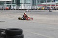 Focused kart racing driver on circuit with tire wall