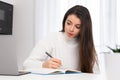 Focused lady student makes notes while listening to lecture