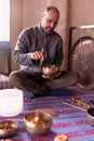 Focused Latino man playing a Tibetan singing bowl