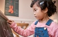 Focused on learning her alphabet. a little girl writing on a blackboard at home. Royalty Free Stock Photo